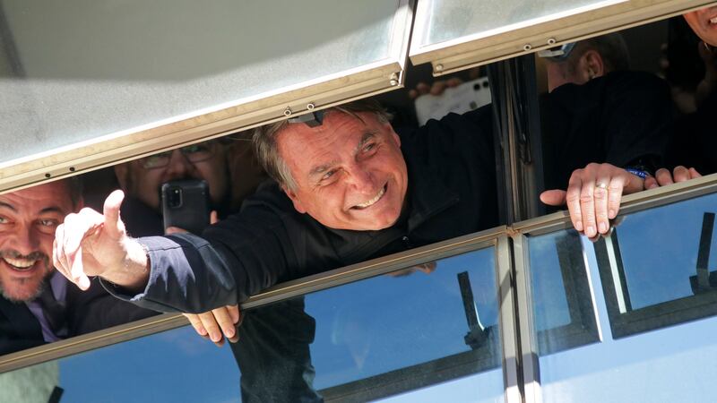 Brazil's former President Jair Bolsonaro waves to supporters at the Liberal Party's...