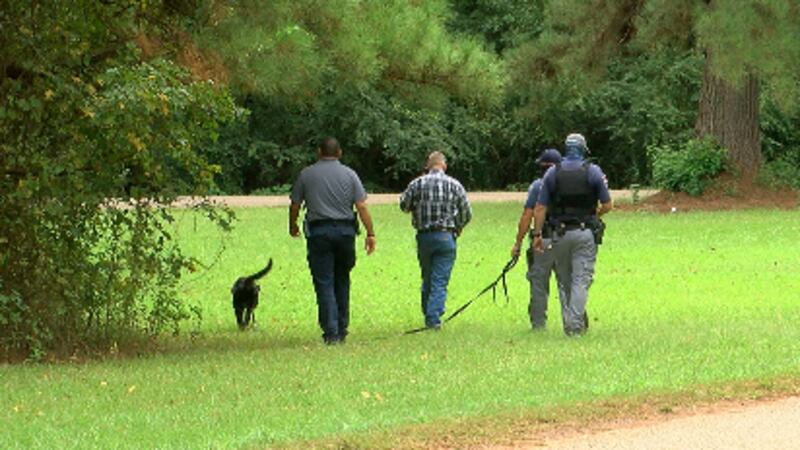 Members of the Texas Department of Criminal Justice walk through areas around Wells with...