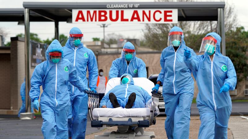 FILE - A person is taken on a stretcher into the United Memorial Medical Center after going...