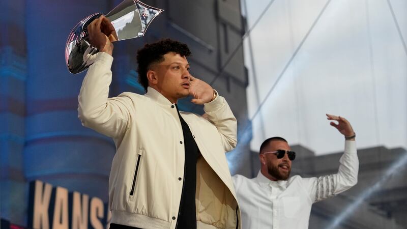 Kansas City Chiefs quarterback Patrick Mahomes, left, holds the Super Bowl trophy as he and...