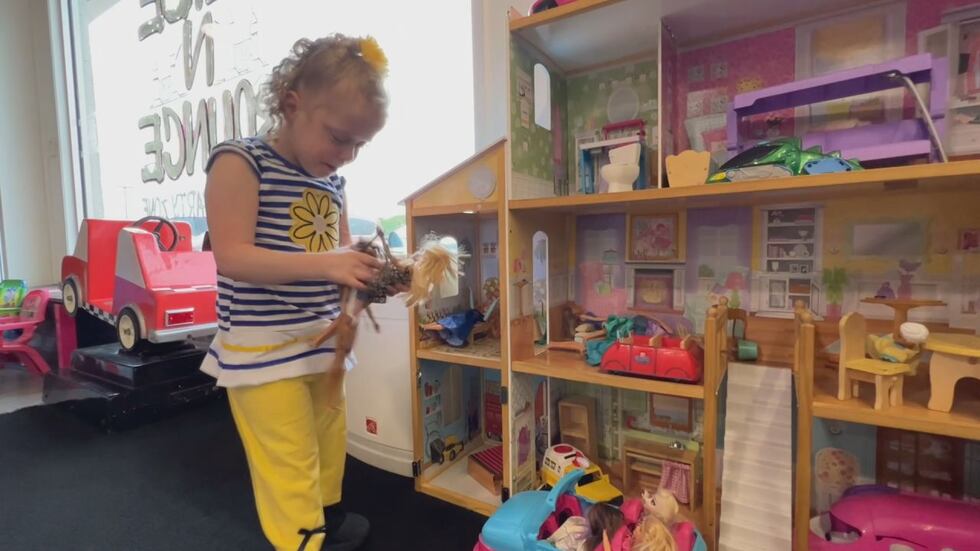 Aurora plays with barbies during playtime at Slide N Bounce Rentals.