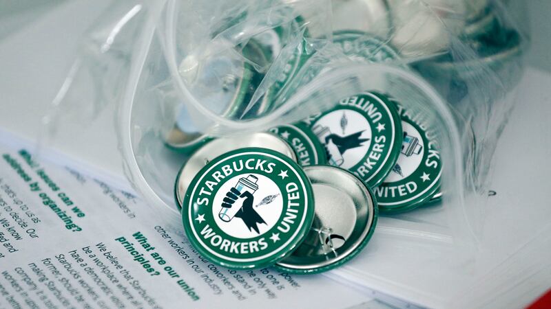 FILE - Pro-union pins sit on a table during a watch party for Starbucks' employees union...